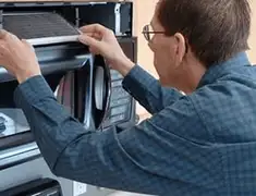 Appliance repair technician replacing a microwave vent filter in Philadelphia, PA